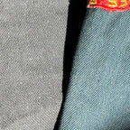 Close-up of gray fabric with a red and yellow logo on the corner.